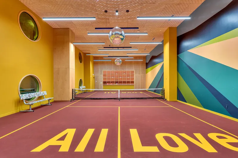 Indoor pickleball court painted with the words All Love